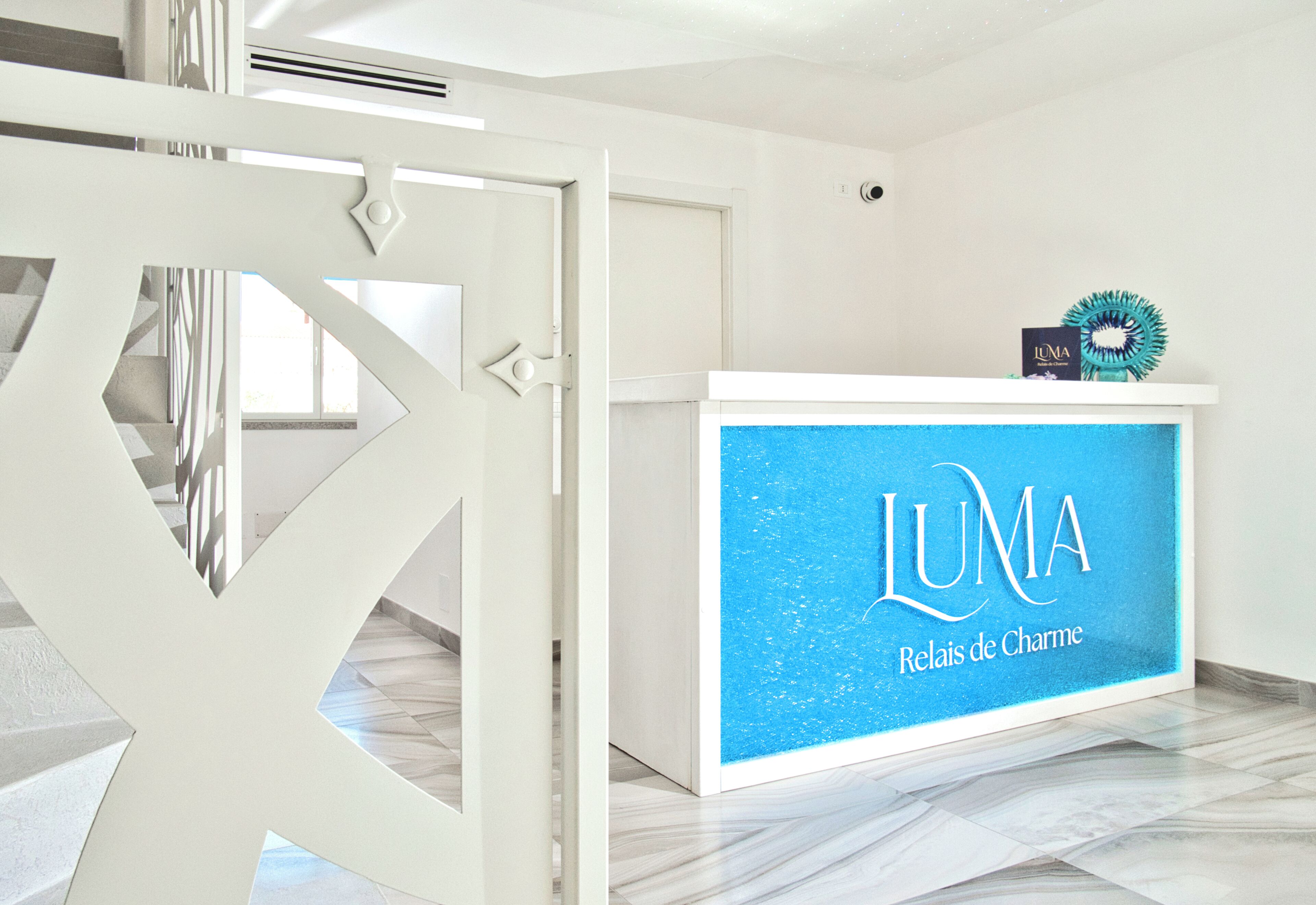 A reception desk with a blue background and the text 'LUMA Relais de Charme.'