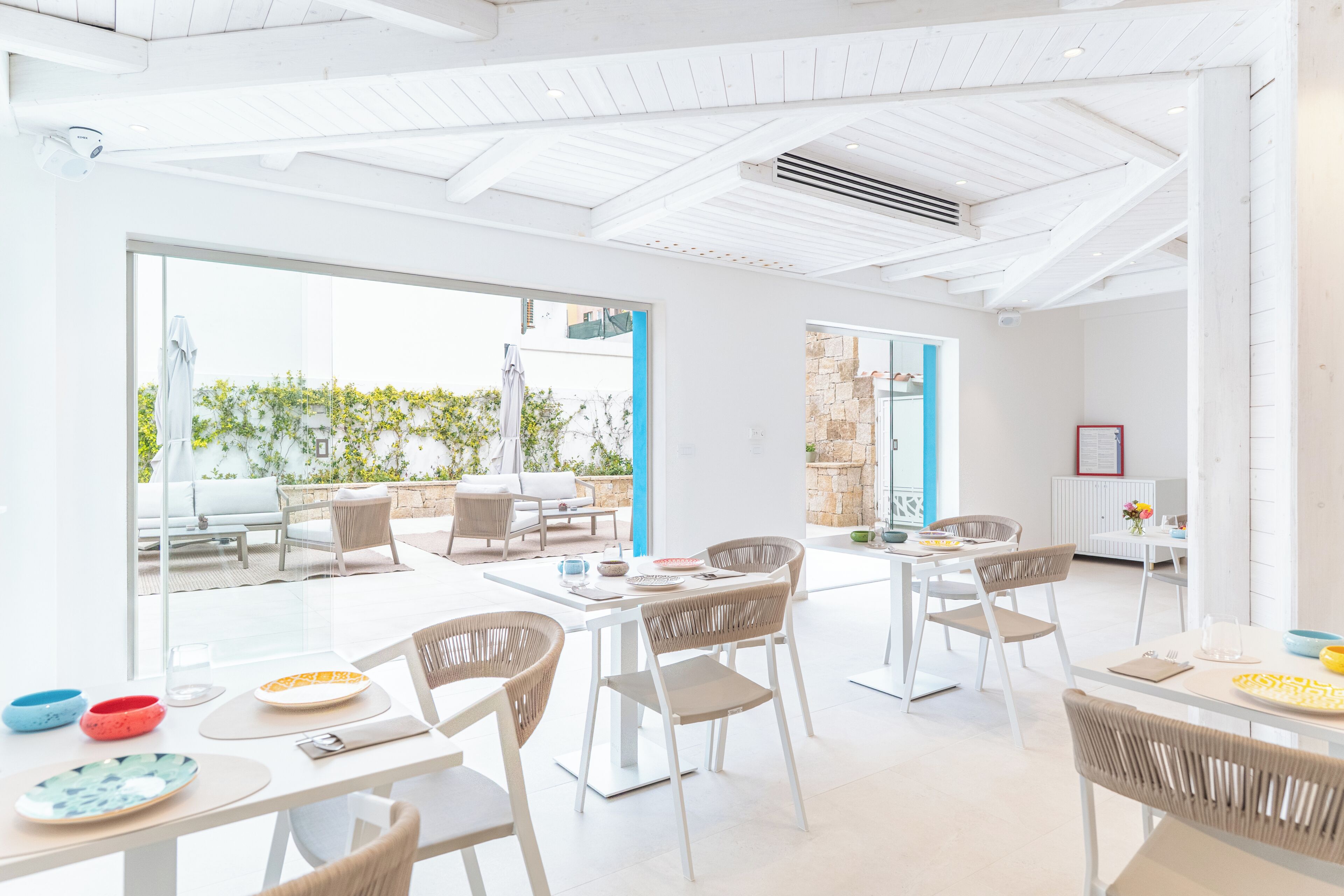 A bright, open-plan dining area with modern furniture and large windows.