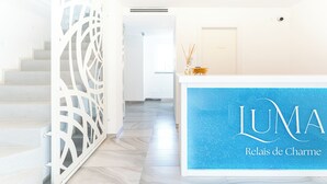 Una mesa de recepción con un letrero azul que dice 'LUMA Relais de Charme'.