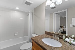 A modern bathroom with a bathtub, toilet, and sink.
