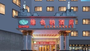 A hotel entrance with a prominent sign in Chinese characters, a classical architectural style with columns, and a statue on top. - Vienna Hotel (Renhe subway station store of Guangzhou Baiyun International Airport) (Guangzhou)