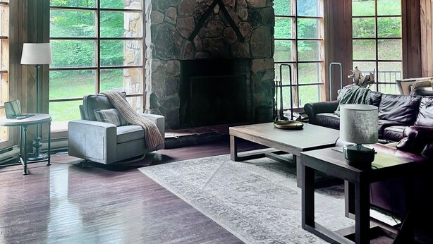 A spacious living room with a stone fireplace, large windows, and wooden beams. - 3 Miles to Hidden Valley! Secluded 3BR + loft w/ WiFi, Hot Tub & Swimming Pool. (Somerset)