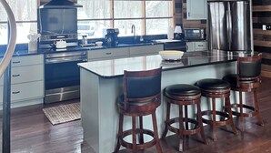 A modern kitchen with a large island, bar stools, stainless steel appliances, and a rustic wooden ceiling. - 3 Miles to Hidden Valley! Secluded 3BR + loft w/ WiFi, Hot Tub & Swimming Pool. (Somerset)