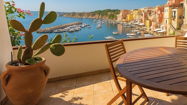 A balcony with a potted cactus, a wooden table, and chairs. - Corricella Hammok - Gioia Apartments (Procida)