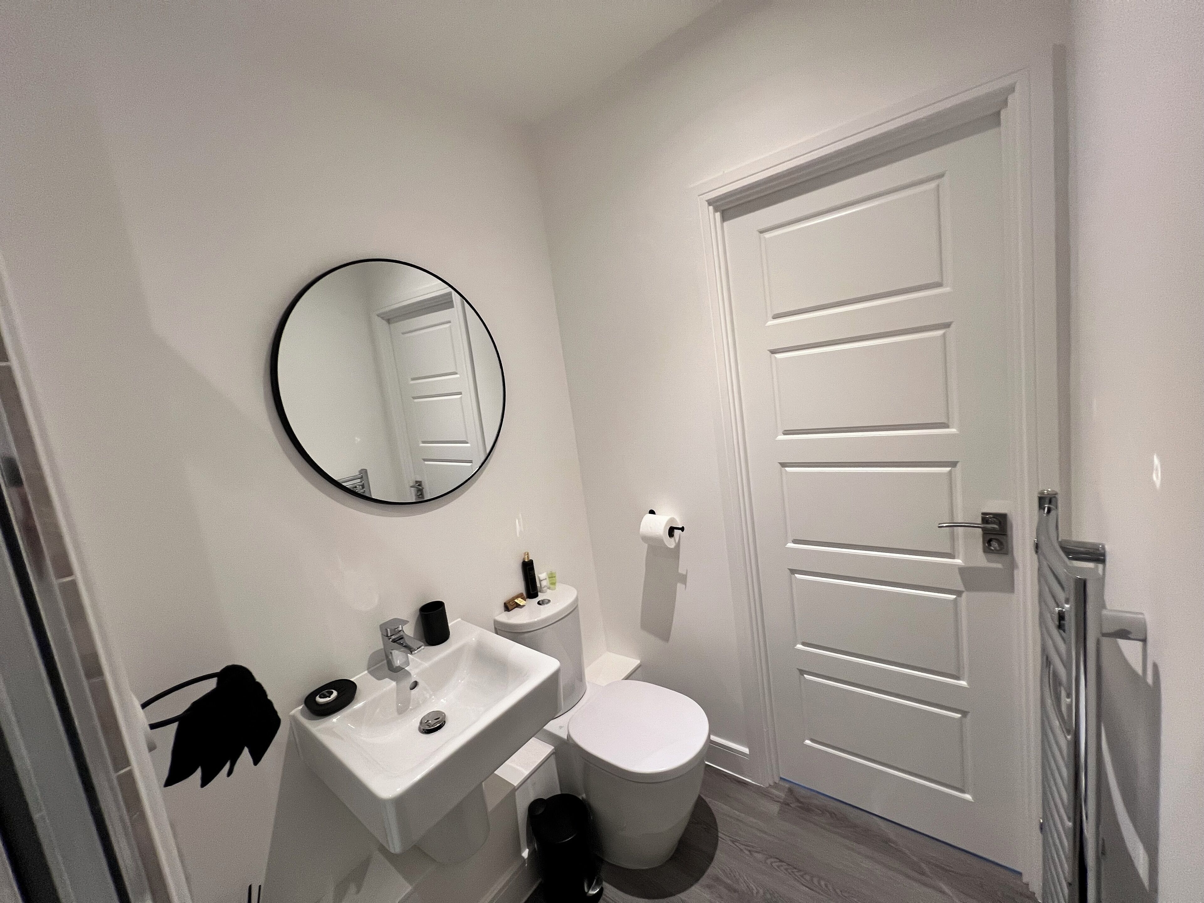 A bathroom with a white sink, toilet, and mirror.
