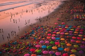 A beach with people and colorful umbrellas. - Swiss-Belcourt Sunset (Bali)