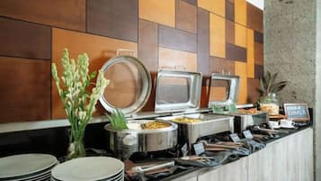 Een buffetopstelling met diverse bakken en een bordje met de tekst 'Ontbijtbuffet'.
