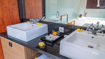 Een moderne badkamer met twee wasbakken, een grote spiegel en een zwart aanrecht.