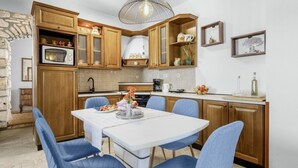 Una cocina con armarios de madera, una mesa de comedor blanca y sillas azules.