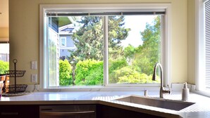 A kitchen with a large window, a sink, and a dish rack. - Wonderful 4-bdrm, 2.5 bath home in Renton,15 min to Seattle,2 min to Coulon Park (Renton)