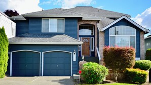 A two-story house with a dark blue exterior, a brick entrance, and two garage doors. - Wonderful 4-bdrm, 2.5 bath home in Renton,15 min to Seattle,2 min to Coulon Park (Renton)
