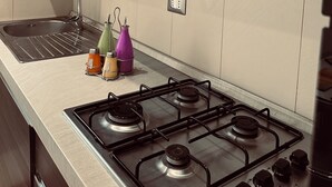 A modern kitchen with a gas stove, a sink, and a range hood. - Charming apartment with 3 bedrooms and WiFi, AC in marvelous Catania (Catania)