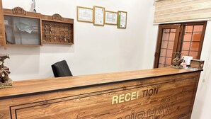 A reception desk with "RECEPTION" and "DEMIRHAN KONAGI" engraved on it. There are certificates on the wall above the desk. - BABİ NEFES Demirhan Konağı (Mardin)