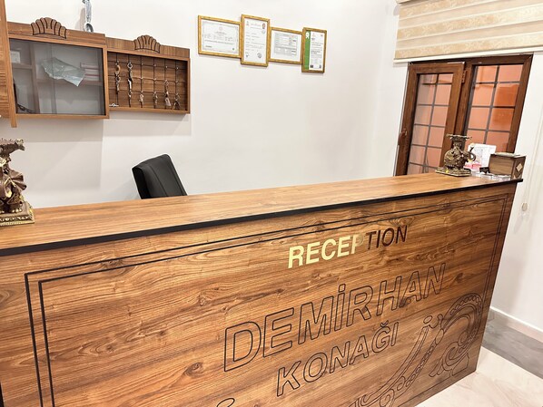 A reception desk with 'RECEPTION' and 'DEMIRHAN KONAGI' engraved on it. - BABİ NEFES Demirhan Konağı (Mardin)