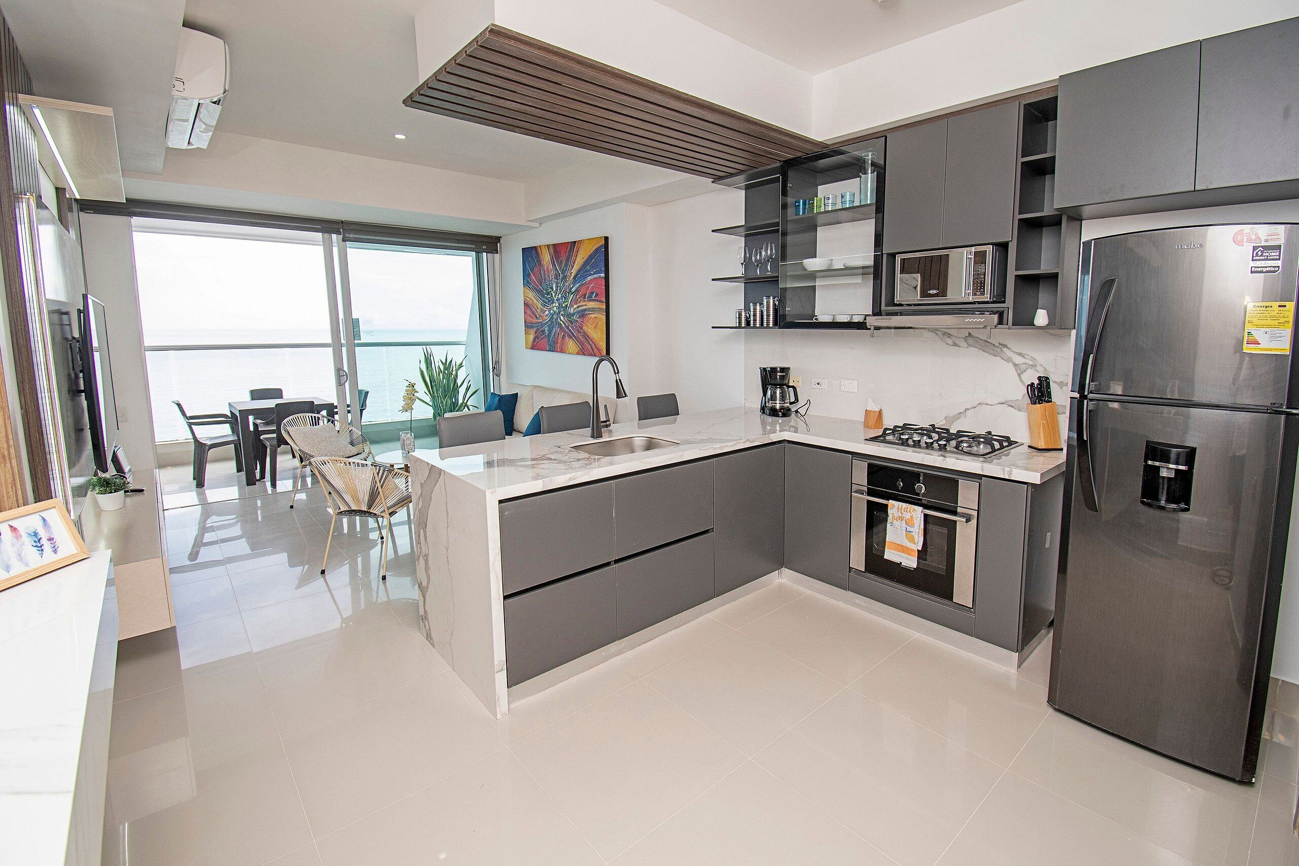 Een moderne keuken met een inbouwfornuis, magnetron en koelkast.