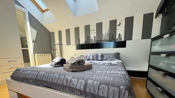 A bedroom with a bed, a wardrobe, a mirror, and a skylight. - Casa Ribera del Pisuerga - Piscina Privada a 10 Minutos del Centro de Valladolid (Arroyo de la Encomienda)