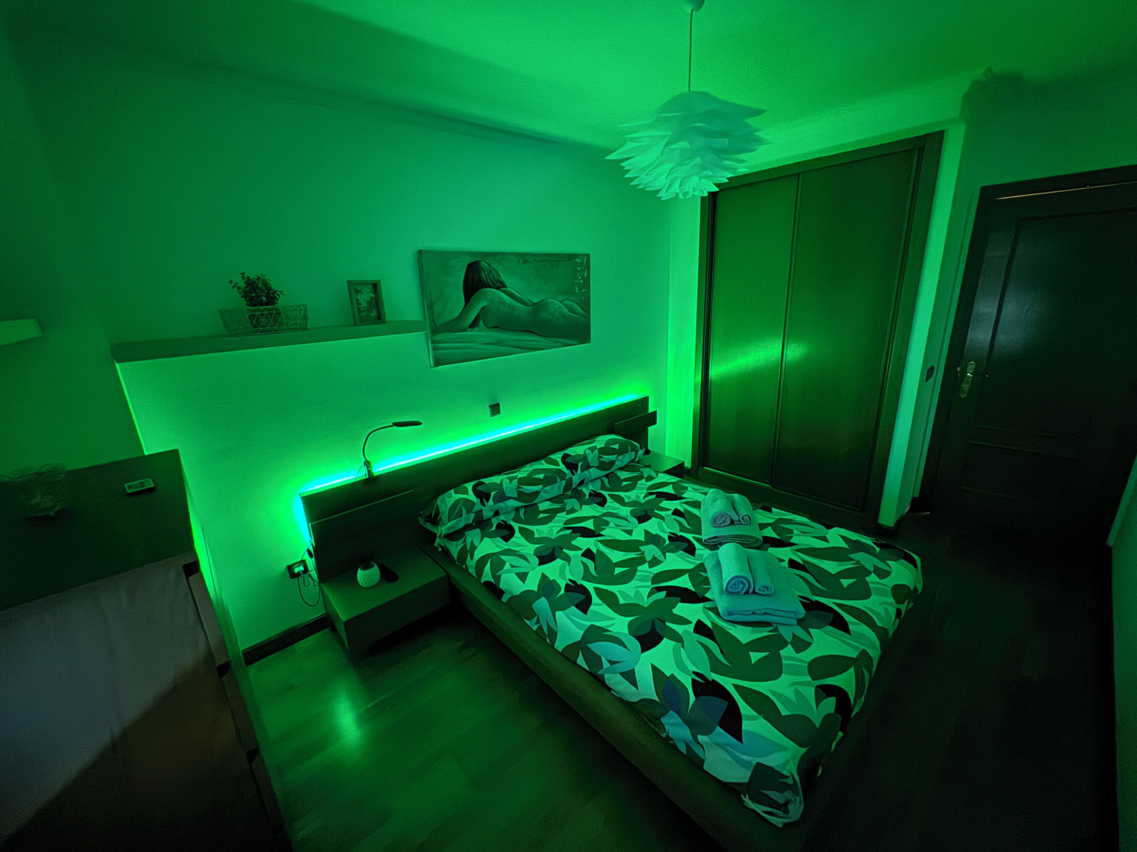 Une chambre à coucher comprenant un lit, une table de chevet, une commode et une étagère murale décorative.