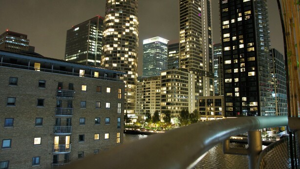 A nighttime cityscape with tall buildings and a bridge. - Lux 2 Bed in Canary Wharf Close to Excel & O2 (London)