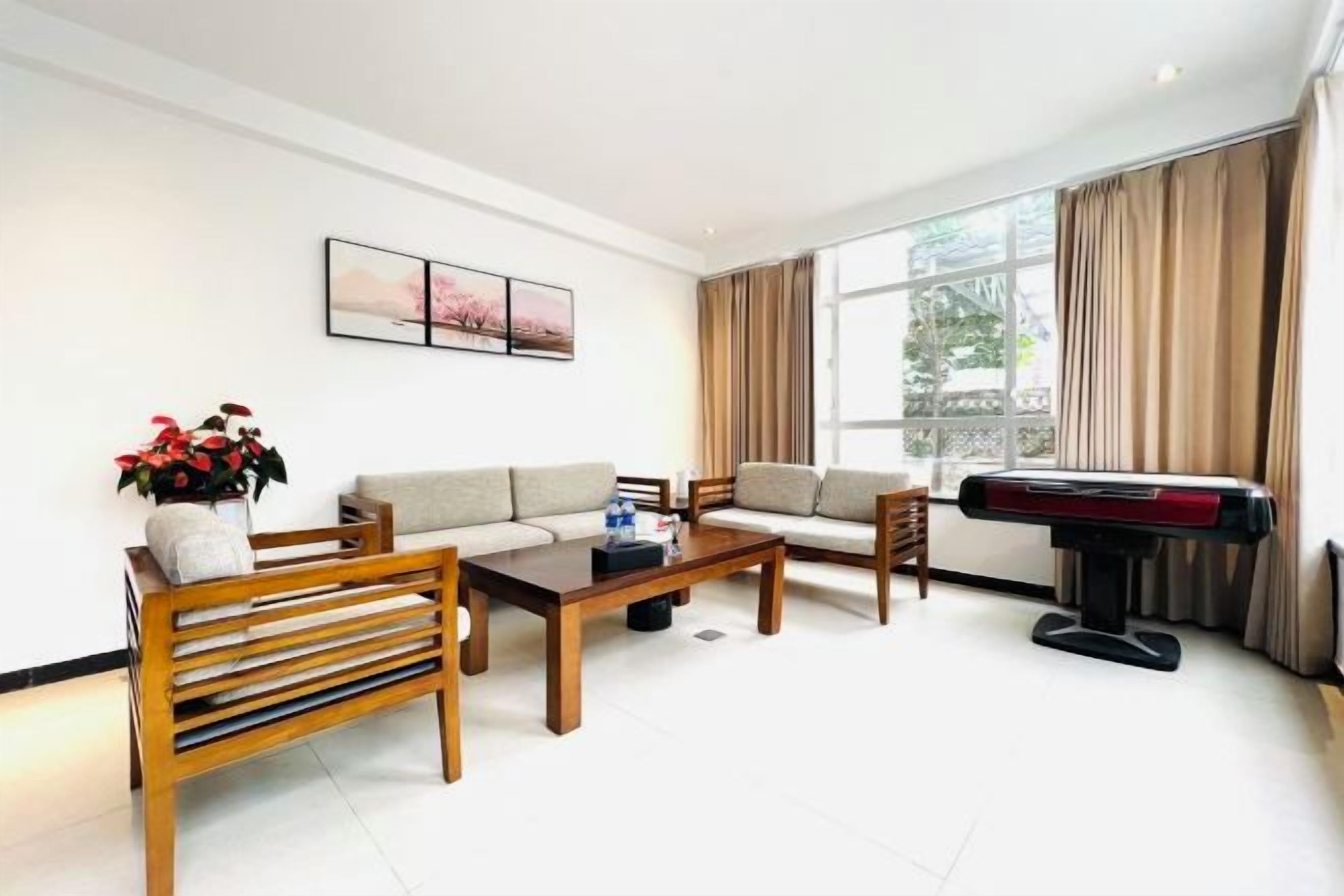 A living room with a sofa, chairs, a coffee table, and a piano.