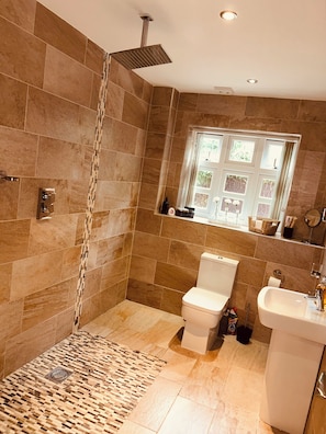 A modern bathroom with a shower, toilet, sink, and a window with a view. - Claverley Hideaway Apartment Bridgnorth (Wolverhampton)
