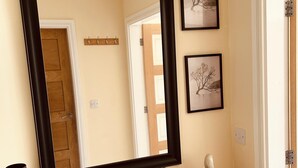 A wooden dresser with a large mirror, two framed pictures, and a small figurine. - Claverley Hideaway Apartment Bridgnorth (Wolverhampton)