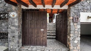 Una entrada de paredes de piedra con una reja de metal y un letrero que dice 'La Maravillas'.