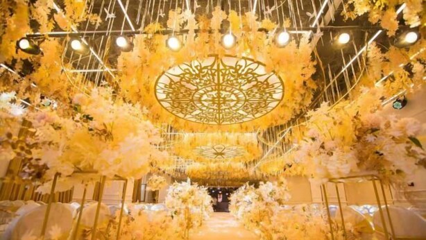 A corridor with a golden pathway, flanked by white floral arrangements and a decorative ceiling design. - Vienna International Hotel (Tongliao Kerqin) (Tongliao)