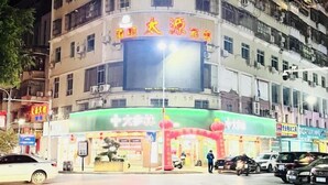 A multi-story building with a large illuminated sign above the entrance. - Taiyuan Hostel (Dabu)