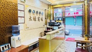 A hotel reception area with a water dispenser, a counter, and a view of the street outside. - Taiyuan Hostel (Dabu)