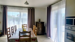 Un comedor con una mesa dispuesta para cuatro, un armario y un microondas.