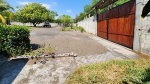 Um bairro residencial com calçada pavimentada, porta de garagem de madeira e muro de concreto.