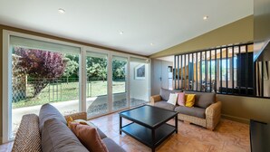 Un ampio soggiorno con divano, tavolino e balcone con porte in vetro.