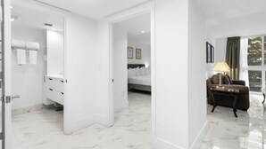 Une chambre d’hôtel avec une salle de bain, un lit, un canapé et une fenêtre avec des rideaux.