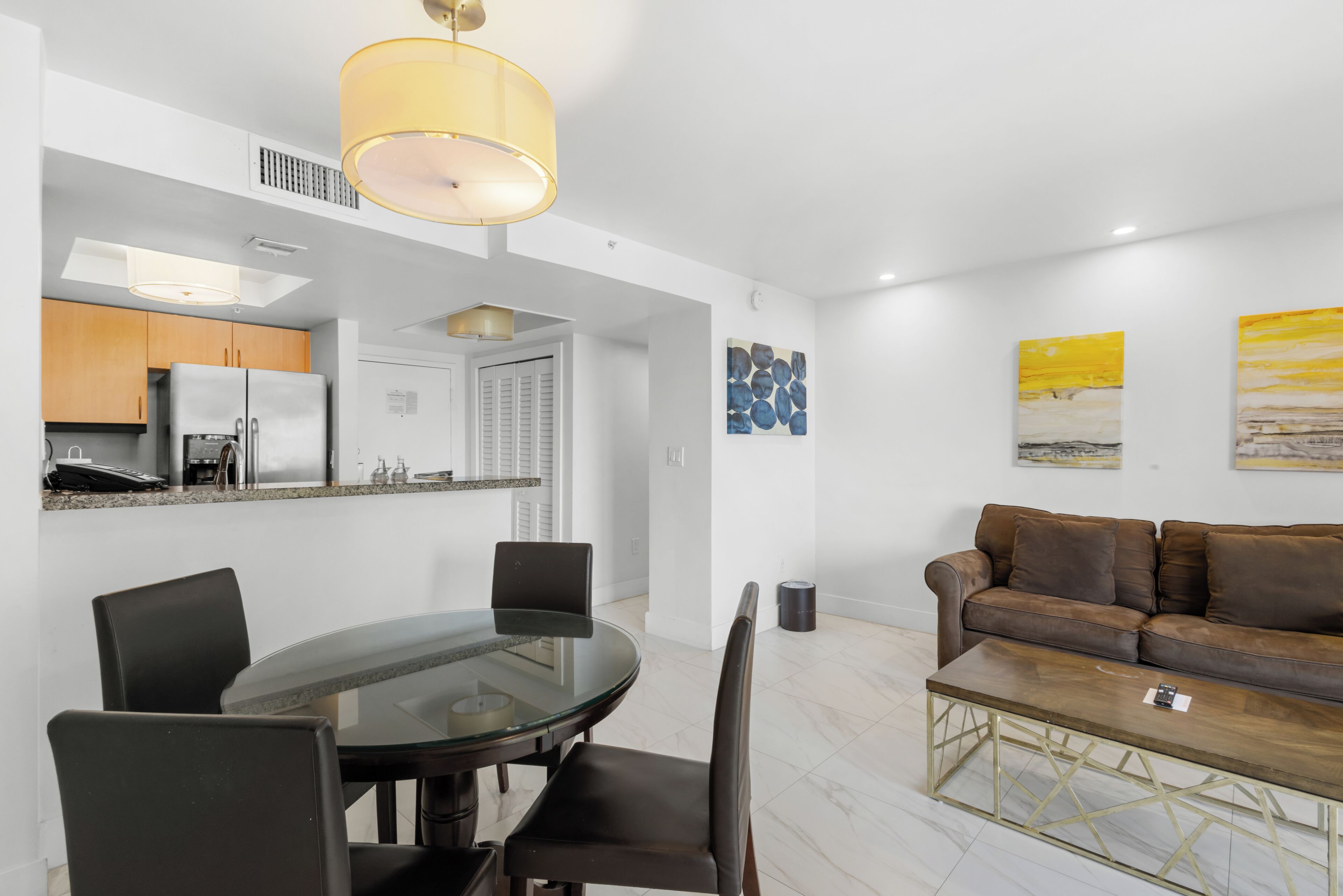 A modern living space with a dining area, kitchen, and seating area.