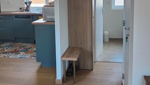 Une cuisine moderne avec des meubles en bois, un banc et une vue sur l’extérieur.