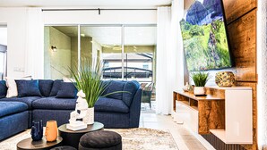 A modern living room with a sectional sofa, a coffee table, and a large painting on the wall.