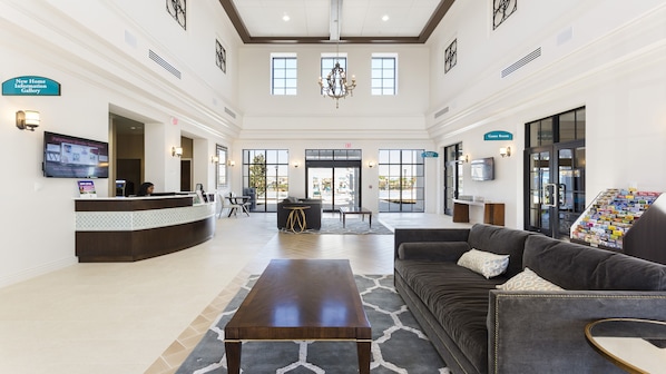 A spacious lobby with a reception desk, seating area, and a Game Room.