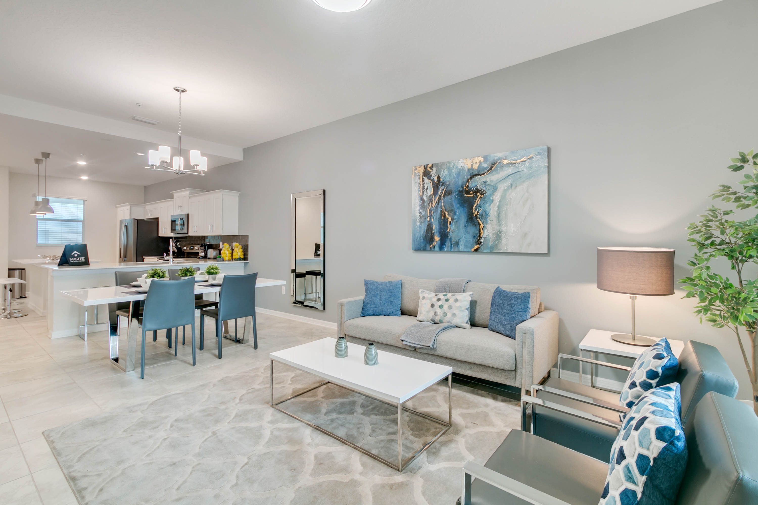 A modern living room with a sofa, coffee table, and dining area.