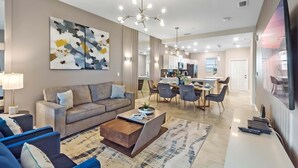 Un salon moderne comprenant un canapé, une table basse et un coin repas avec des chaises et une table.