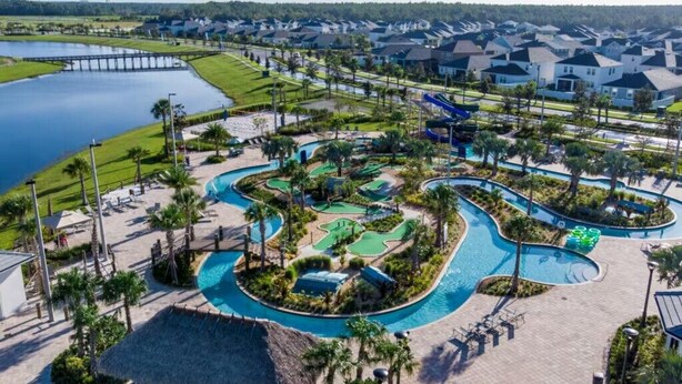 A golf course with a water feature, surrounded by a residential area with houses and a dock. - Last Minute Disney Getaway! Luxury Condo with Private Balcony. Book Now! #65877 (Orlando)