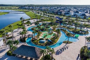 A golf course with a water feature, surrounded by a residential area with houses and a dock. - Last Minute Disney Getaway! Luxury Condo with Private Balcony. Book Now! #65877 (Orlando)