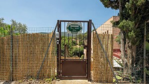 Una entrada con puerta de rejas y un letrero que dice "Casa Vacanze Tra i Verdi Pini".