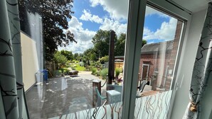 Une pièce dotée d’une grande porte-fenêtre coulissante donnant sur un patio extérieur.
