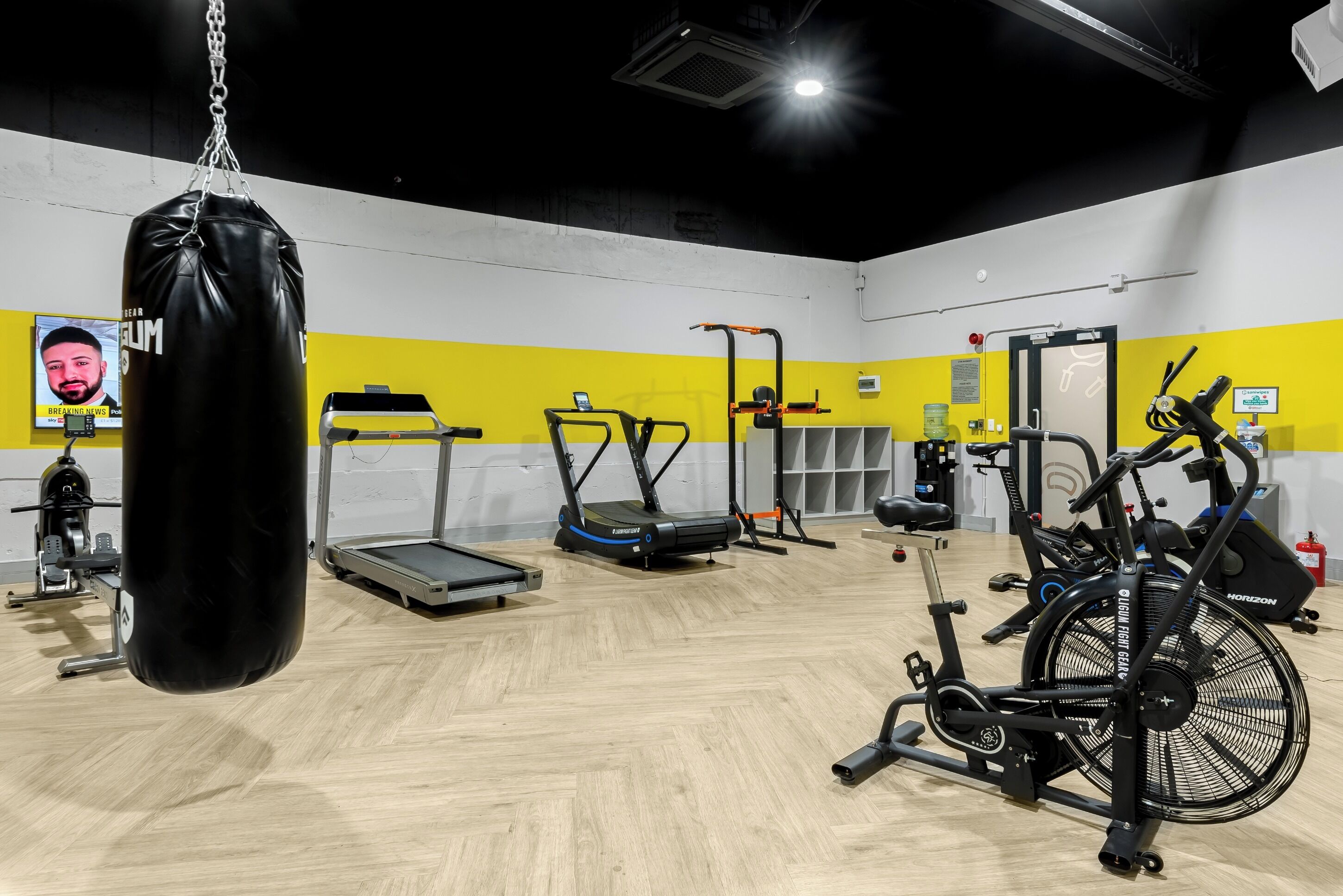 A gym with a punching bag, treadmills, and stationary bikes.