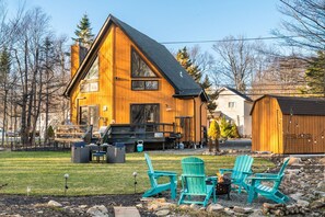 A wooden cabin with a deck, outdoor seating, and a fire pit. - Pet Friendly, Pocono Chalet, Lake Community (Tobyhanna)