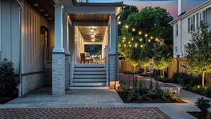 A house with a covered porch, outdoor seating, and string lights.