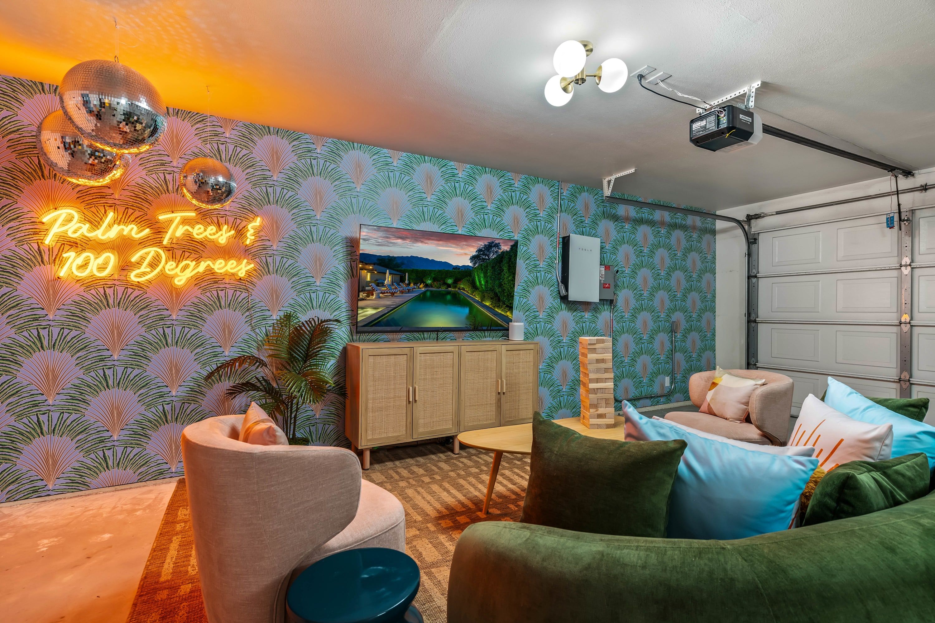 Ein Wohnzimmer mit einer Neonreklame, einem Fernseher und einer Garagentür.
