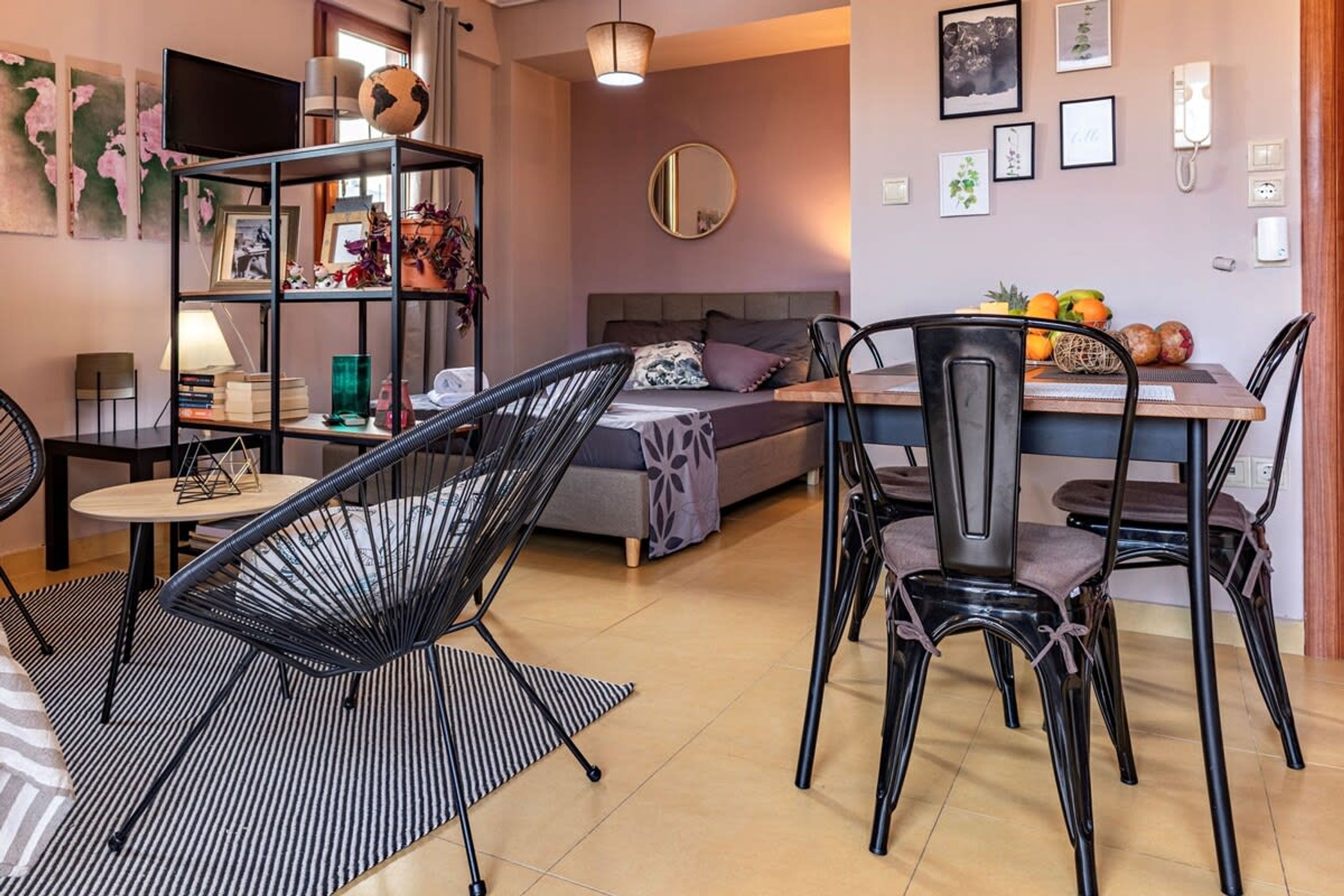 Un salon moderne comprenant un canapé, une table à manger avec des chaises, une bibliothèque et un téléviseur.