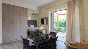 A compact bedroom with a bed, bedside table, and a large wardrobe. - Estia Coastal Dream - Lush Enchanting Garden Gem (Pylos-Nestoras)