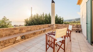 Eine Terrasse mit Steinstufen, einem Tisch und Stühlen sowie Meerblick.